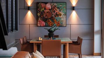 Ein modernes Wohnzimmer mit Essbereich, ausgestattet mit einer Couch, einem Couchtisch und einem Bild an der Wand.