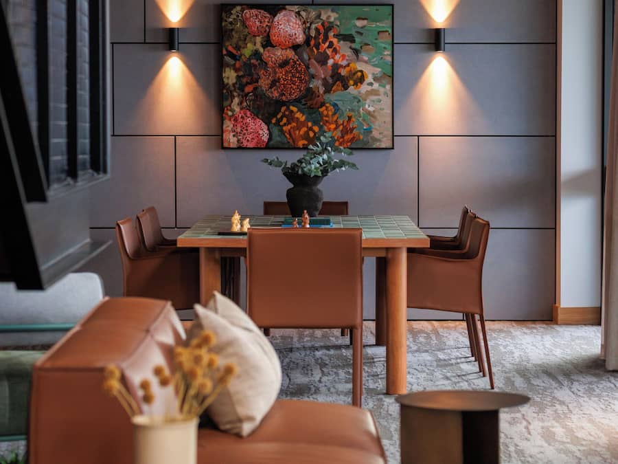Un salon moderne avec un coin repas, comprenant un canapé, une table basse et un tableau au mur.