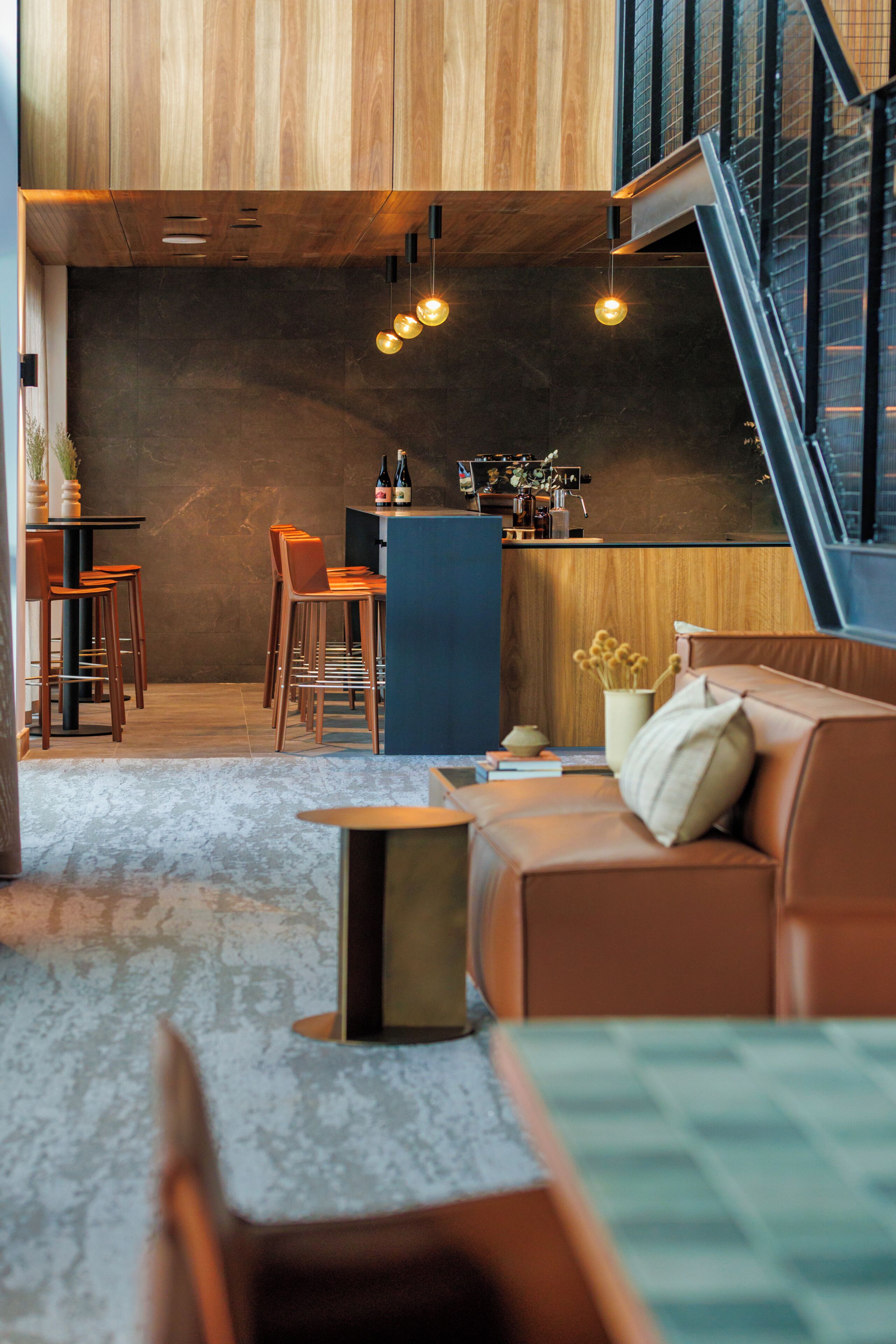 A modern interior with a bar area, seating, and a staircase.