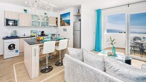 Un appartamento moderno con cucina, zona pranzo e balcone con vista.