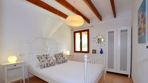 A bedroom with a bed, bedside tables, a window, a wardrobe, and a decorative light fixture. - NEW Charming country estate with swimming pool in the middle of nature (Selva)