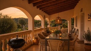 An outdoor patio with a table and chairs, a grill, and a view of the landscape. - NEW Charming country estate with swimming pool in the middle of nature (Selva)