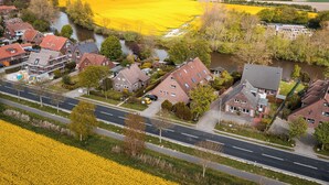 Ein Wohngebiet mit Häusern, einem Fluss und Feldern voller gelber Blumen.