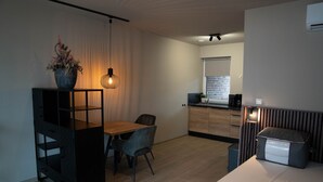 Een moderne keuken met een eetgedeelte, een ingebouwde bank en een plant in pot.