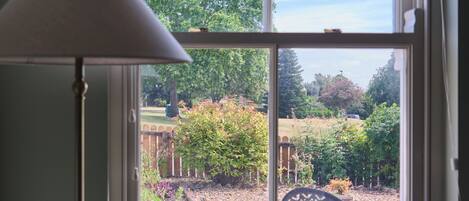 A room with a window overlooking a garden.