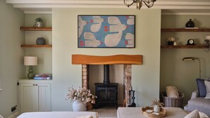 Un accogliente soggiorno con camino, un lampadario e un quadro sopra.