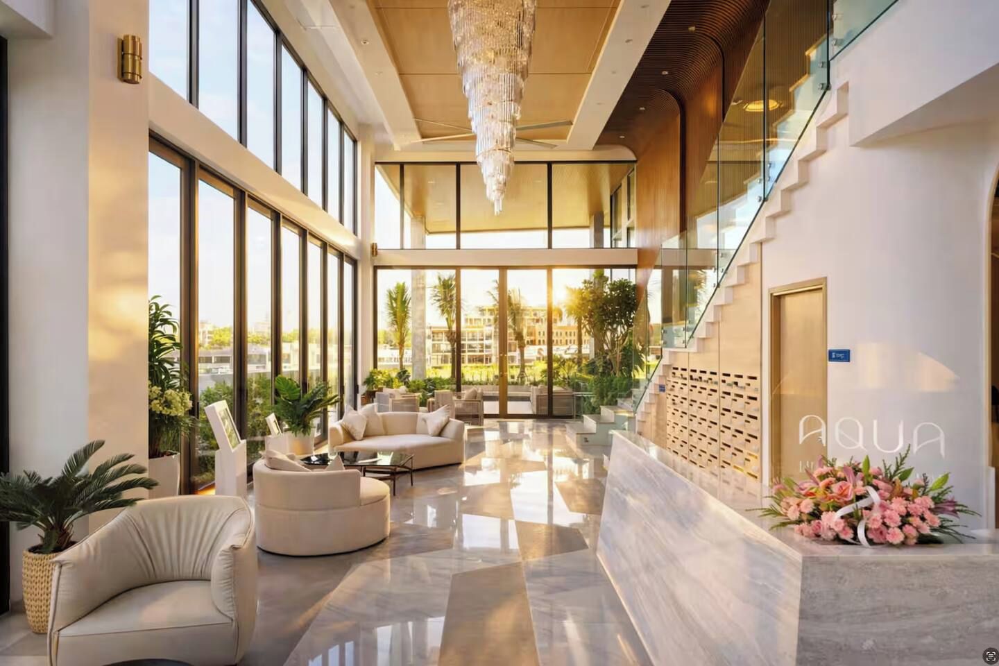 Eine geräumige Lobby mit hoher Decke, großen Fenstern und einer Treppe.