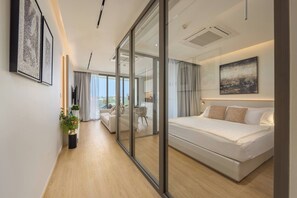 Une chambre moderne avec un grand lit, une cloison en verre et une vue sur le paysage urbain.