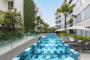 A modern hotel with a rooftop pool, glass railings, and palm trees. - The Aqua Luxury Apart Hotel Waterfront (Choeng Thale)