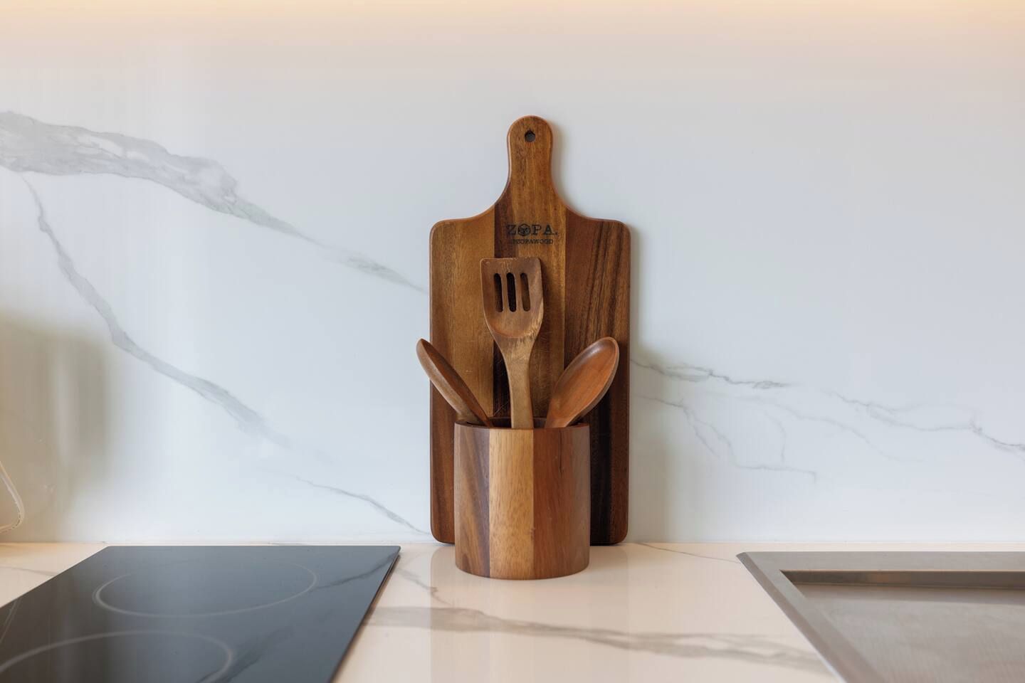 Een keukentafel met een houten snoerhouder met een spatel en een lepel.