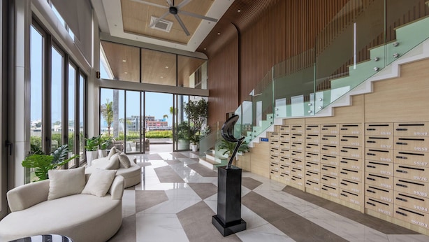 Eine moderne Lobby mit Sitzgelegenheit, einer Treppe und einer Wand mit Briefkästen.