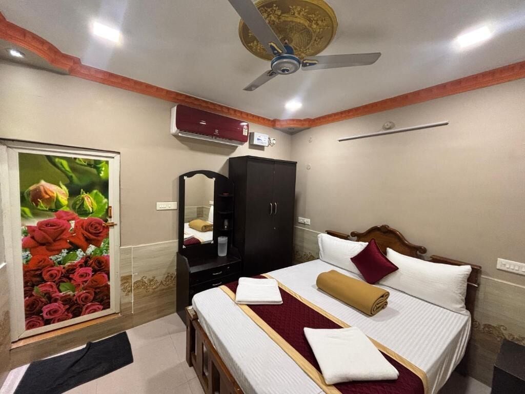 Habitación de hotel con cama, armario, ventilador de techo y aire acondicionado de pared.