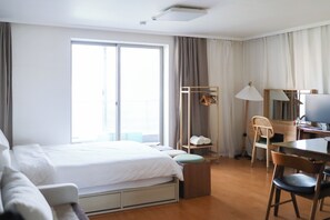 A hotel room with a bed, a desk, a chair, a wardrobe, and a large window. - JS building-401 (Seoul)