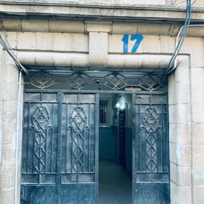 A building entrance with a number '17' above a metal gate with geometric patterns. - Apartment No. 1 – Steps from Downtown 4 Bedrooms (عمان)