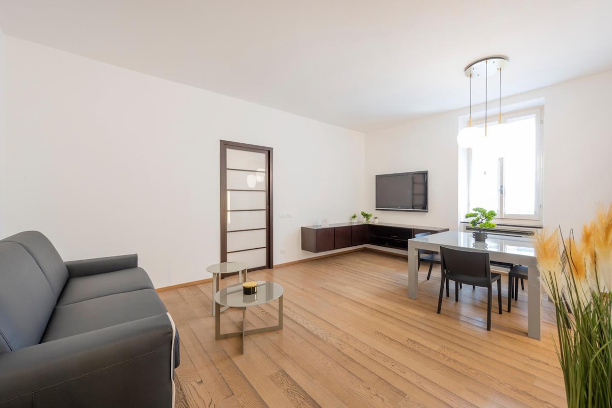 Un salon moderne comprenant un canapé, une petite table basse et un coin repas avec une table et des chaises.