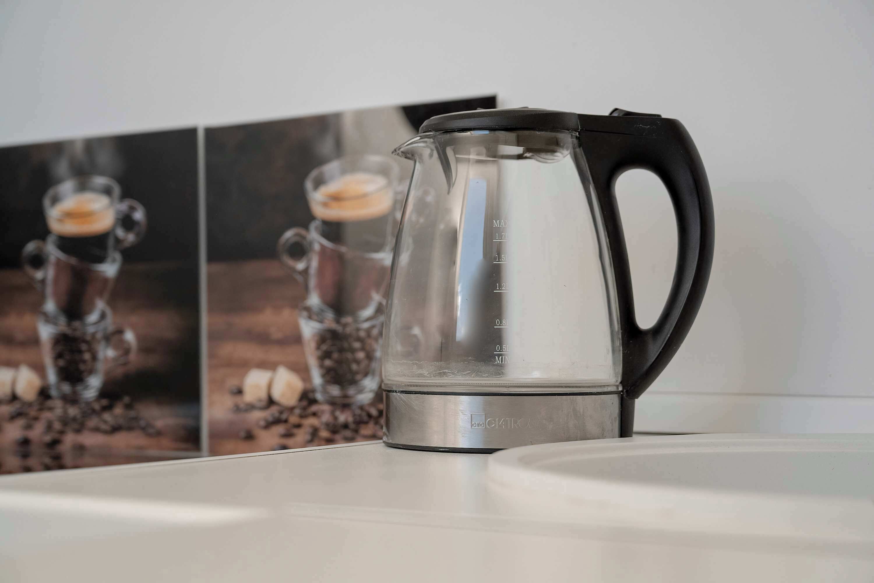 Una cafetera de vidrio transparente con medidas marcadas sobre una mesa.