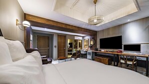 A hotel room with a large bed, a desk with a computer, a TV, and a chandelier. - Brown Dot Daegu Exco (Daegu)
