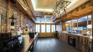 A cozy bar area with a coffee machine, wooden walls, and a fireplace. - Brown Dot Daegu Exco (Daegu)