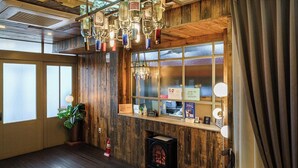 A wooden interior with a fireplace, a plant, and a window with frosted glass. - Brown Dot Daegu Exco (Daegu)