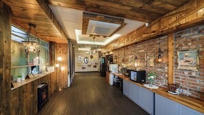 A rustic interior with wooden beams, a brick wall, and a counter with various items. - Brown Dot Daegu Exco (Daegu)