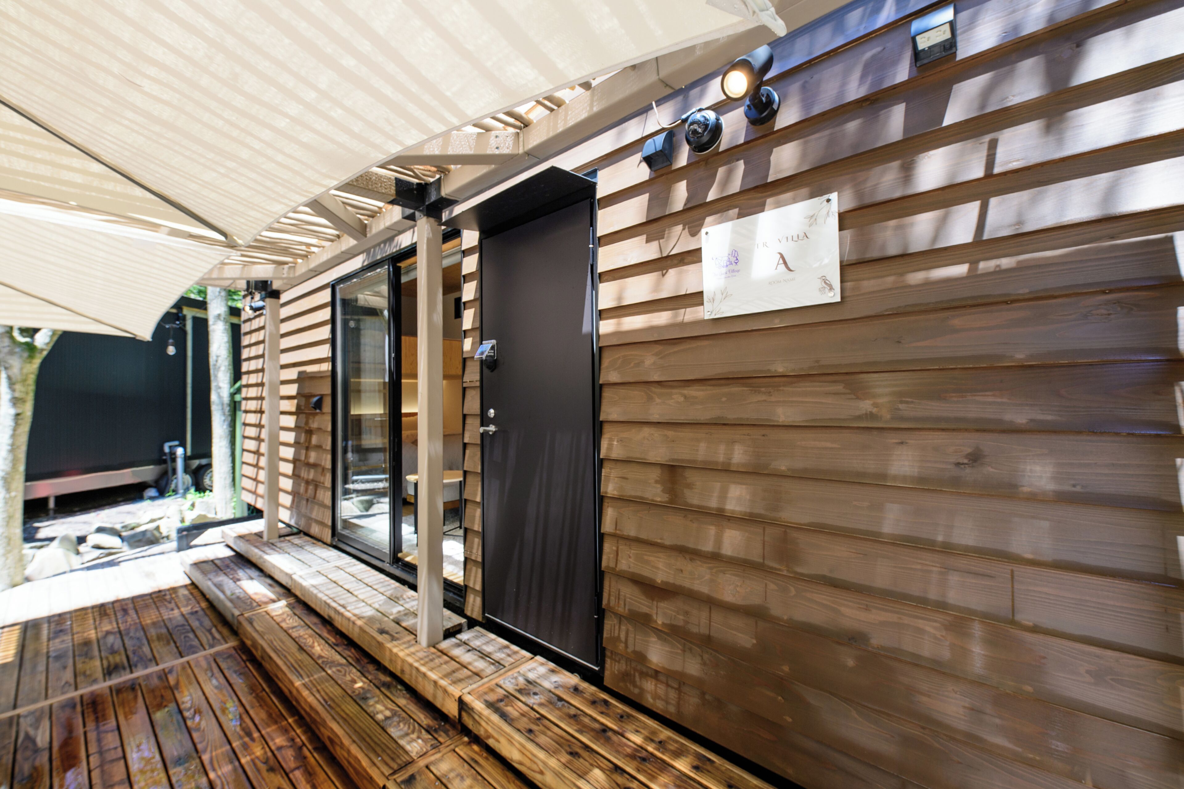 A wooden exterior wall with a door, a window, and a sign.