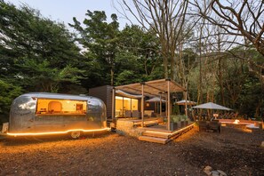 A modern RV with a kitchen area, a wooden deck, and outdoor seating. - THE GUEST VILLAGE Hakone Ashinoko (Hakone)