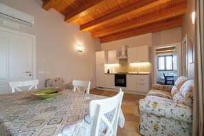 A cozy interior with a dining area, a sofa, and a kitchen. - Donnafugata - Relax with Terrace View of the Iblei Mountains (Giarratana)