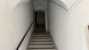 A narrow stairway with white walls and a black handrail. - Casa di Ada (Imperia)