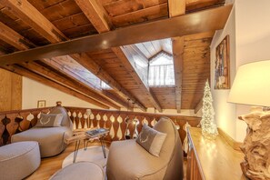 Ein gemütliches Loft mit Holzbalken, einer Holzreling und einem kleinen Weihnachtsbaum.