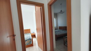 Une chambre avec un lit, une table de chevet et un ventilateur de plafond.