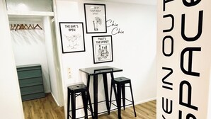 A room with a wooden floor, a white wall with framed artwork, and a black sign reading 'LIVE IN OUTER SPACE'. - Cozy apartment near Lake Constance - ideal for couples (Friedrichshafen)