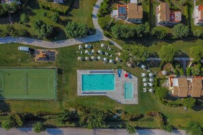 An aerial view of a residential area with a swimming pool, tennis court, and several houses. - Relax, Balcony & Pool Retreat (Numana)