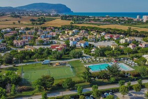 A residential area with houses, a swimming pool, and a sports field. - Relax, Balcony & Pool Retreat (Numana)
