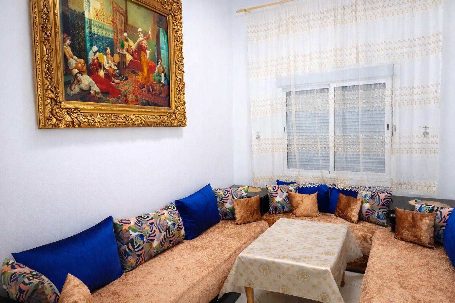 Une pièce comprenant un canapé, une table et un tableau accroché au mur.