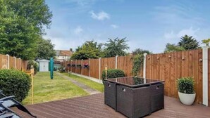 Un espace patio aménagé avec des sièges et une clôture en bois.