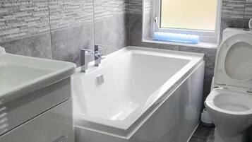 Separate bathtub and shower, deep-soaking bathtub, hair dryer, towels