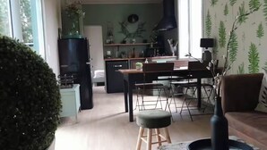 Et moderne køkken med spiseplads, store vinduer og en dekorativ plante.