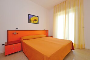 Une chambre à coucher avec un lit, une table de chevet et un tableau accroché au mur.
