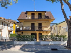 Un immeuble à deux étages doté de balcons, d’une entrée sécurisée et surplombant un ciel dégagé.