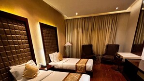 Une chambre d’hôtel avec deux lits, un bureau, une chaise et un ventilateur de plafond.