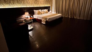 Une chambre d’hôtel équipée d’un lit, d’une table de chevet, d’une lampe et d’un ventilateur de plafond.