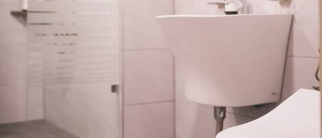 Une salle de bain avec une douche, un lavabo et des toilettes.