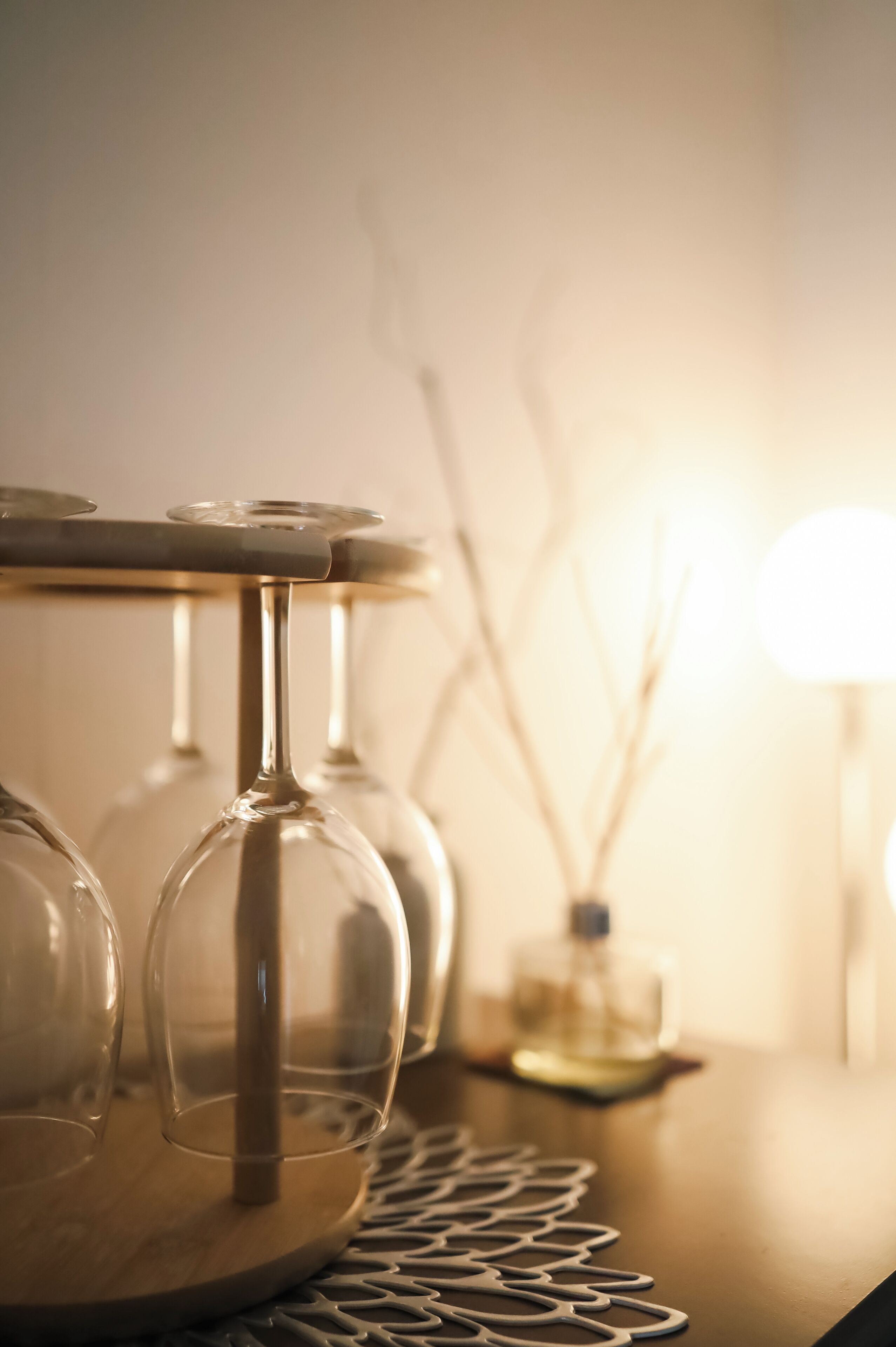 Een close-up van wijnglazen op een houten tafel met een decoratief metalen patroon.