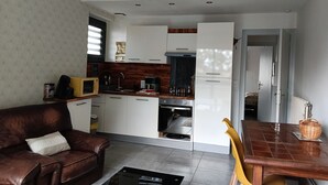 A modern kitchen with white cabinets, a microwave, and a coffee maker. - The Trumpets of Jericho (Tartas)