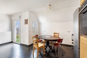 Una cocina moderna con comedor, refrigerador y ventana con vistas.