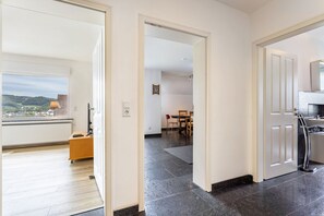 A modern interior with a kitchen, dining area, and a view of the countryside.