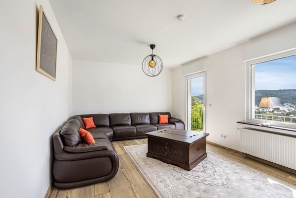 Una sala de estar moderna con un sofá modular, una mesa de centro y un ventanal con vistas.