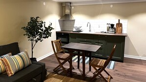 Een moderne keuken met een eethoek, met een bank, een eettafel, stoelen en een potplant.