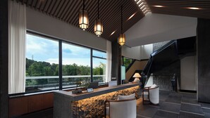 A modern kitchen with a stone island, large windows, and a staircase. - Heart Retret Seasons Village (Foshan)