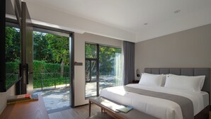 A modern hotel room with a large bed, a bench, a reading area, and a sliding glass door leading to an outdoor area. - Heart Retret Seasons Village (Foshan)